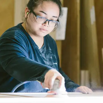 full_93734_image_editor_result Worker sanding the side of cabinets in assembly line