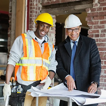 A construction site worker and architect work together on a home-building site.
